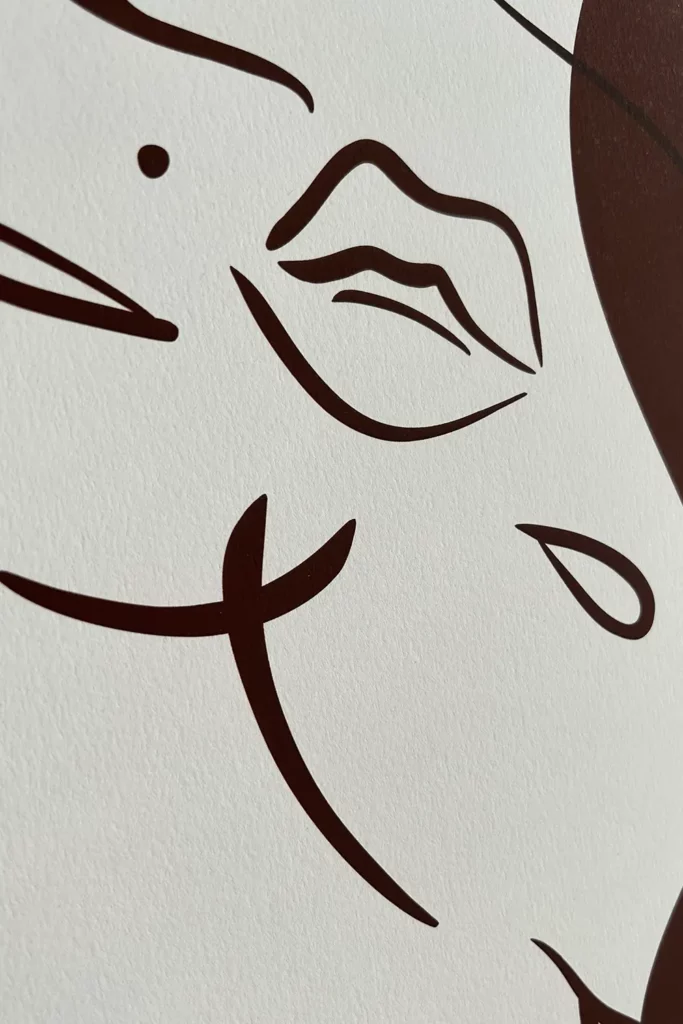 Close-up of a minimalist brown line drawing on white, showing stylized lips, a single teardrop, and abstract facial curves
